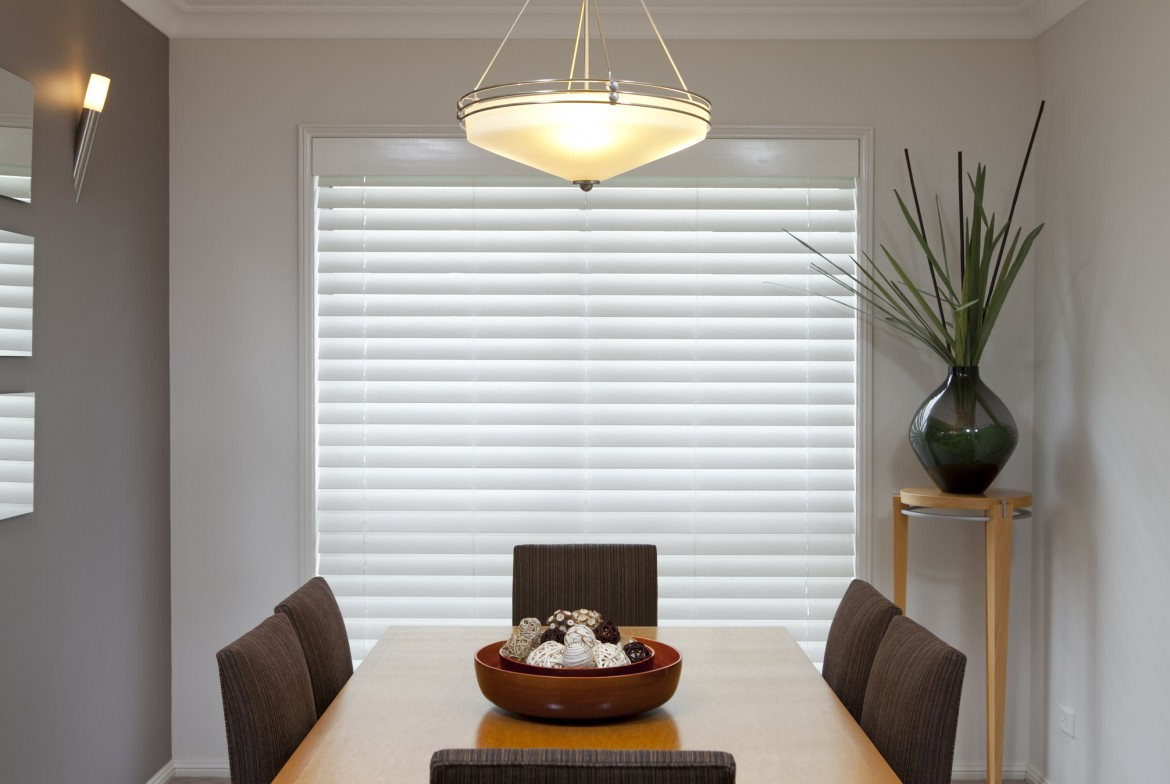 A table with venetian blinds behind