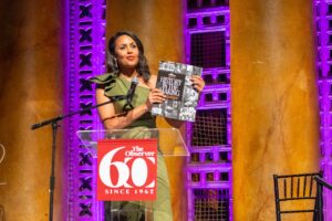 News Nation’s “Morning In America” host Adrienne Bankert holds up a copy of the 100-page commemorative book during The Sacramento Observer’s 60th anniversary gala celebration. Bankert served as the night’s emcee. /Photo by Russell Stiger.