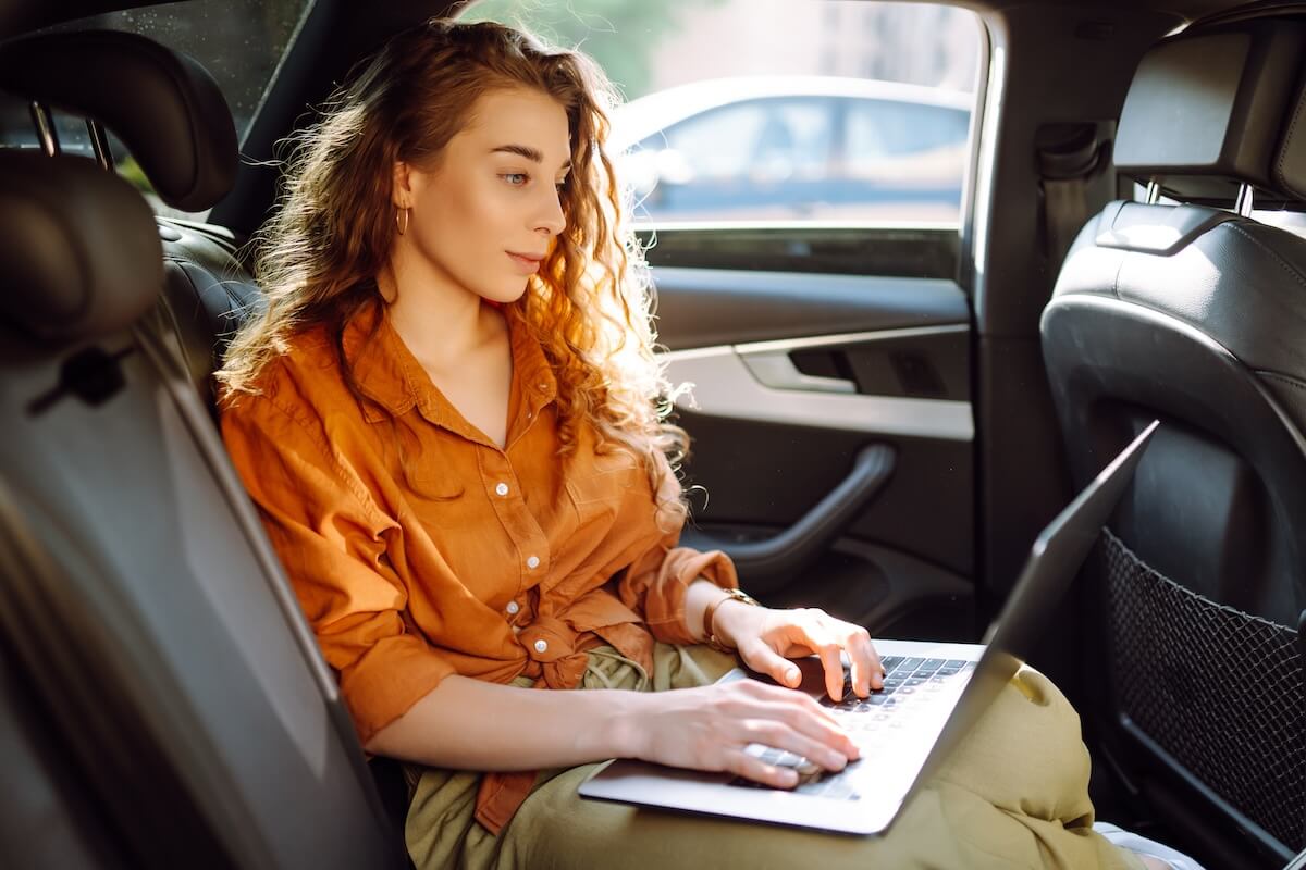 Substance abuse EMR software: entrepreneur using her laptop inside a car