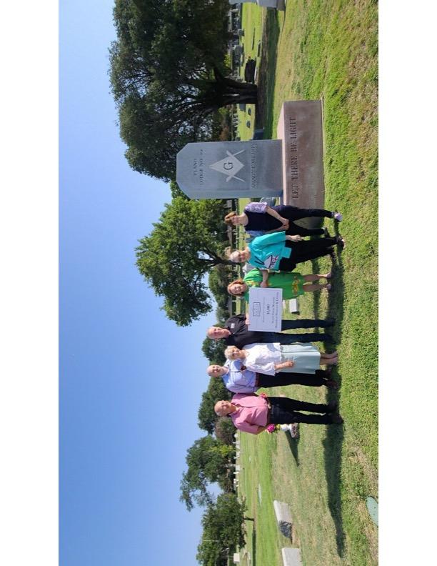 A group of people standing in a cemetery

Description automatically generated