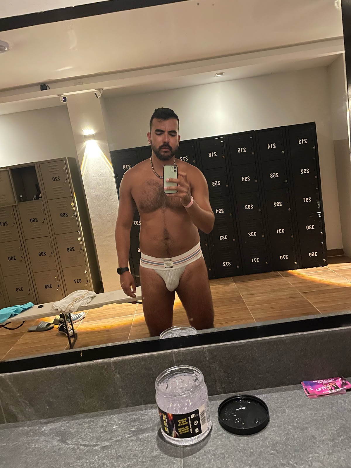 gay male undressing at the bathhouse wearing white jock strap and taking an iphone mirror selfie