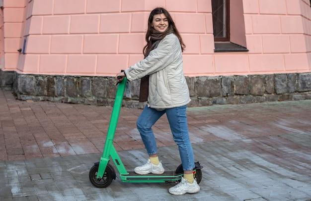 Happy young woman on electric scooter in the city.