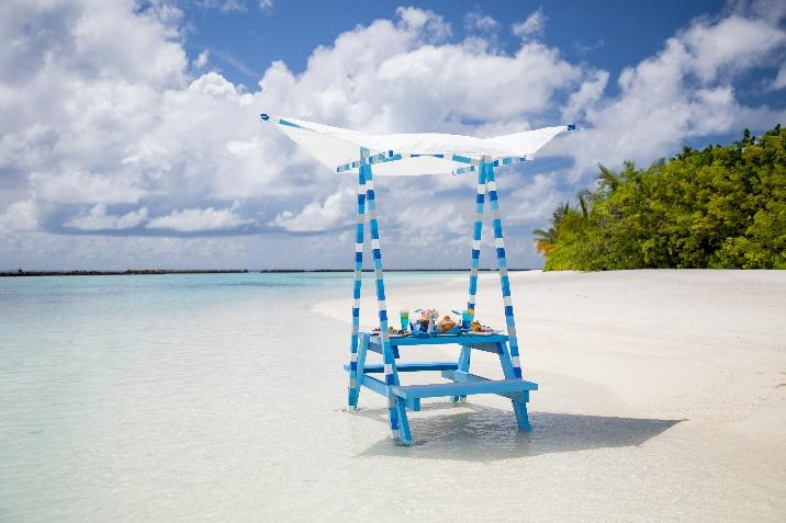 A blue and white picnic table on a beach

Description automatically generated