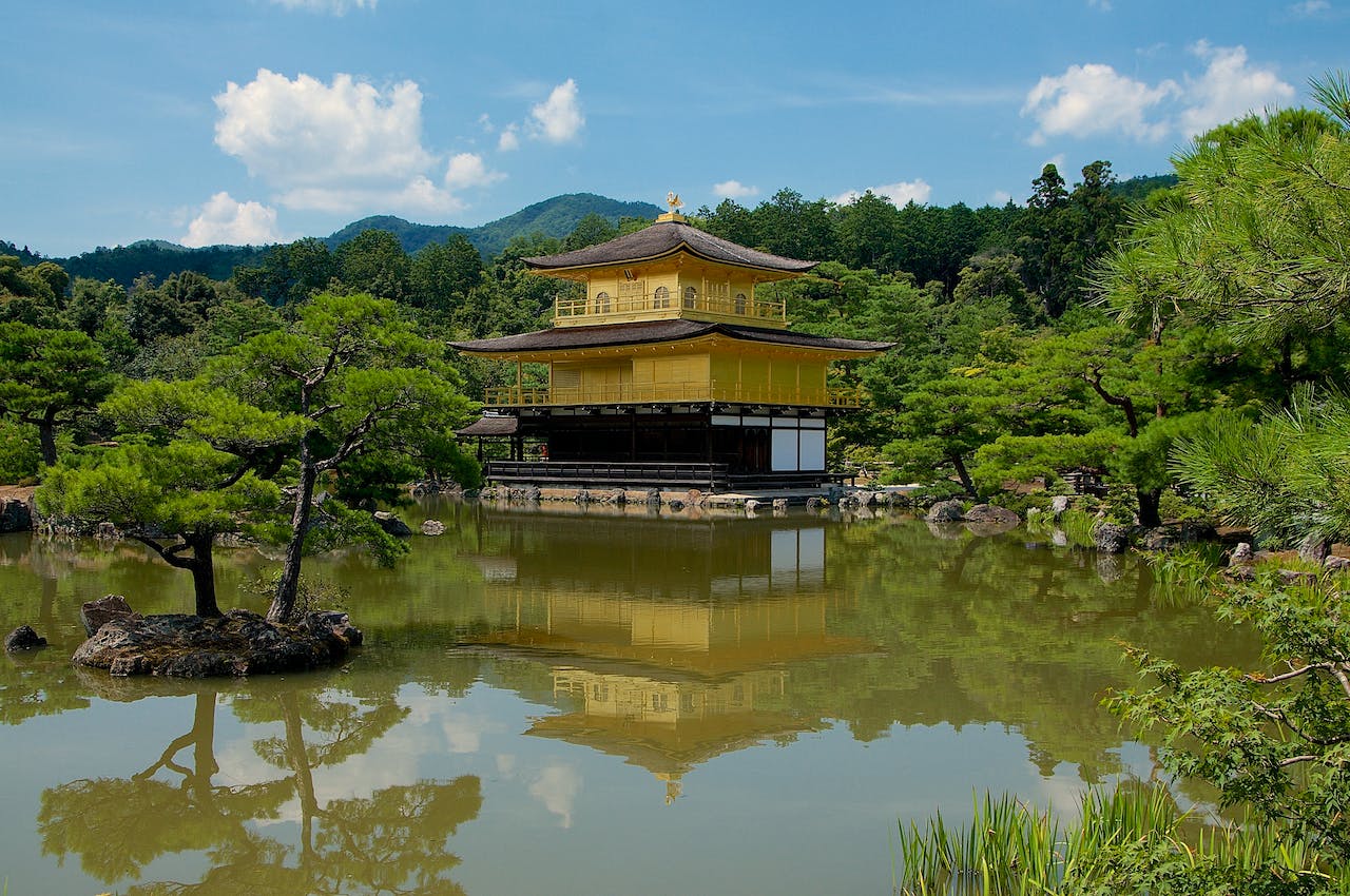 The Kinkakuji Temple surrounded by tress and water. 