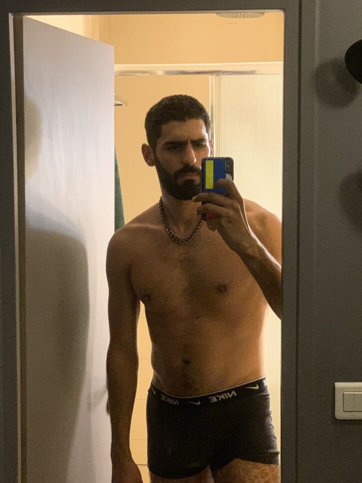 karim yoav taking a shirtless mirror photo with his iphone