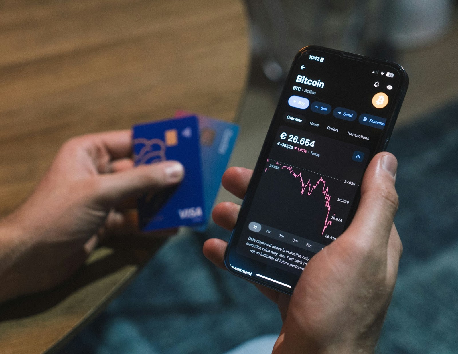 A person holding a smartphone and a crypto credit card