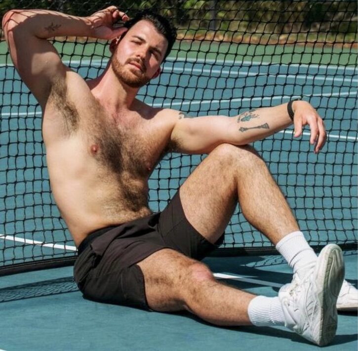 Dillon Cassidy sitting shirtless showing of his hairy muscled chest while posing on the tennis court