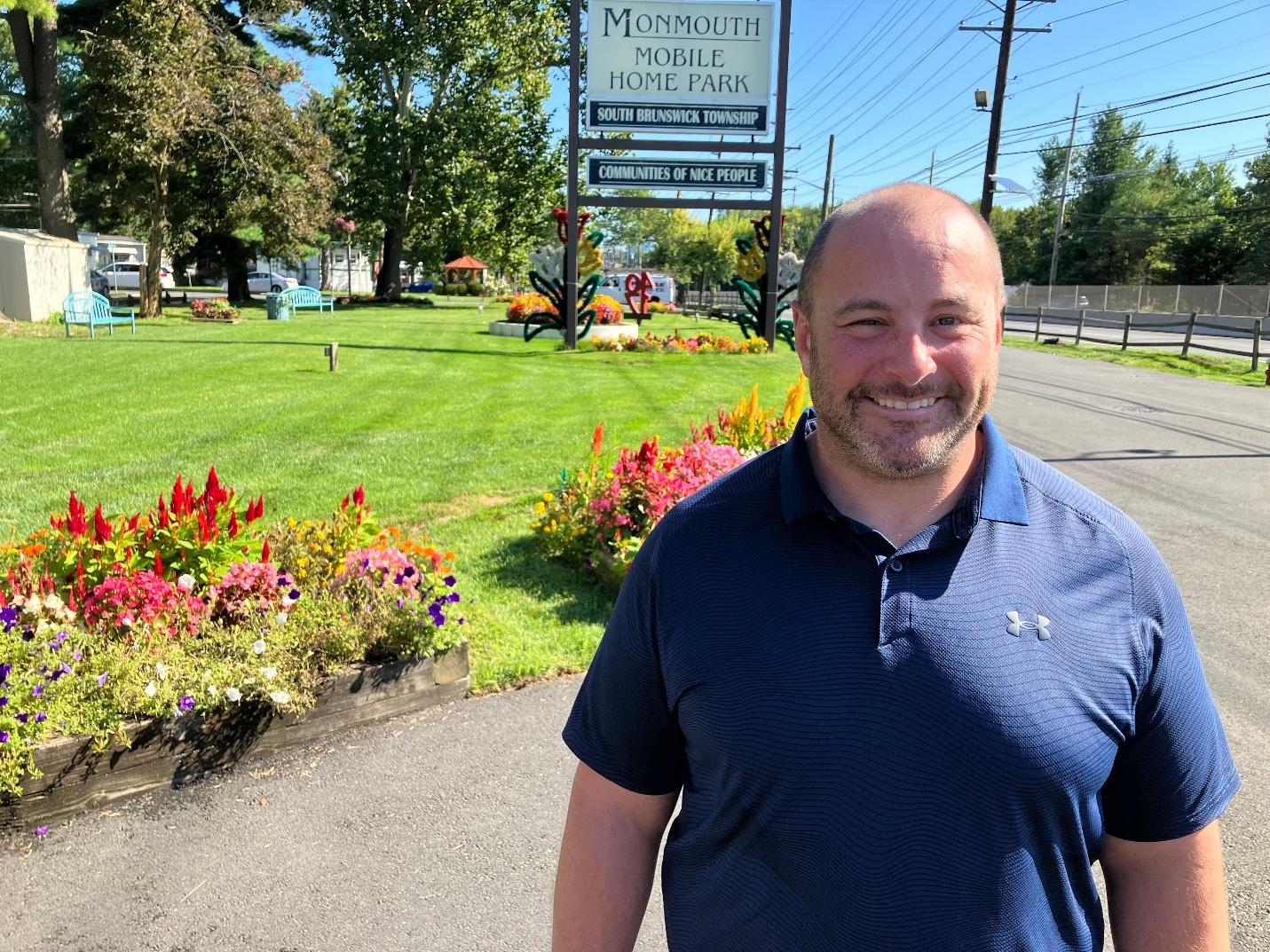 A person standing in front of a sign

Description automatically generated