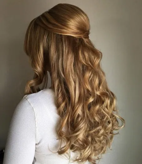 Side view of a lady rocking the curly half up half down hairstyle