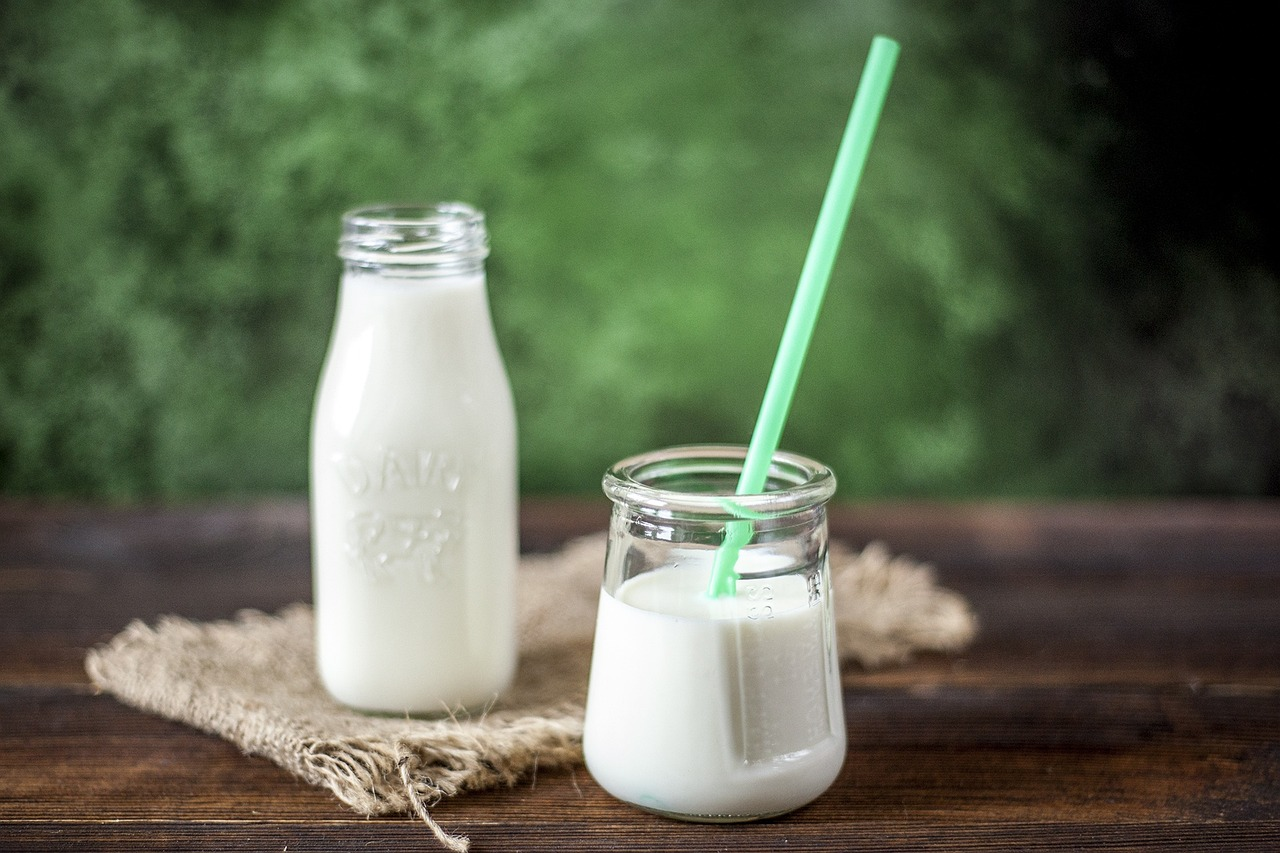 a jug of milk and a glass with a straw