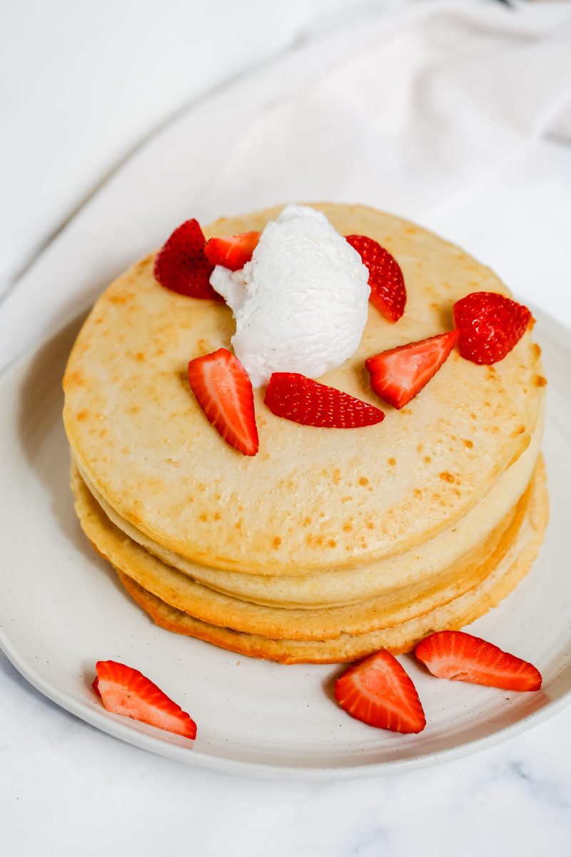 Air fryer pancakes topped with strawberries and syrup.