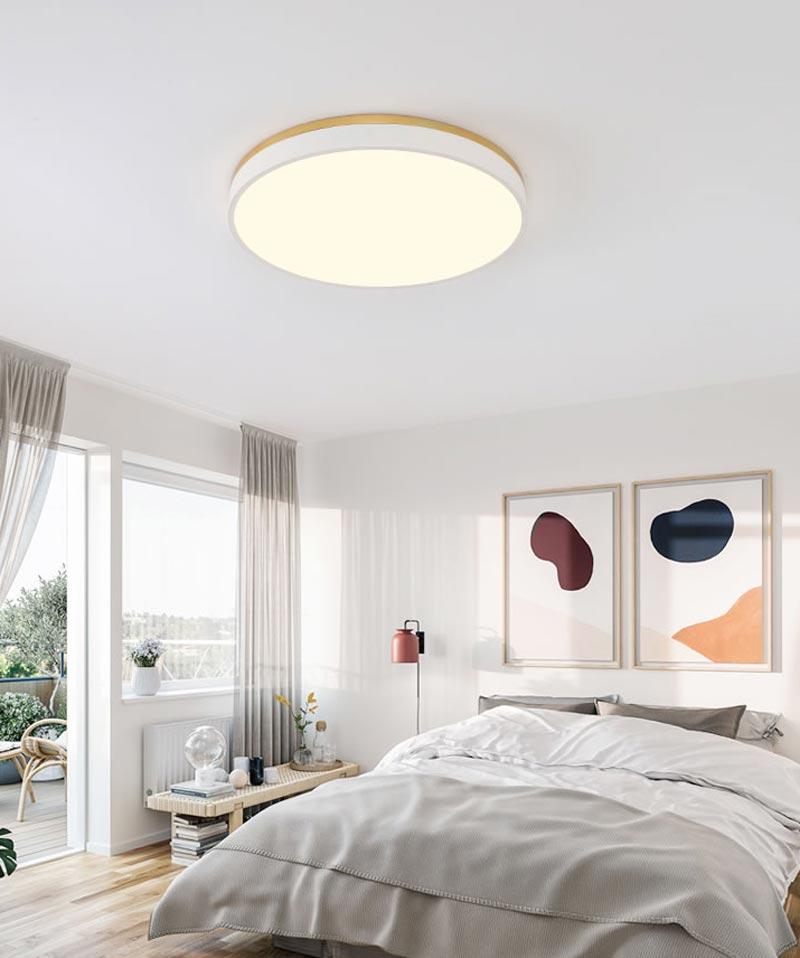 A bedroom with a round light fixture

Description automatically generated