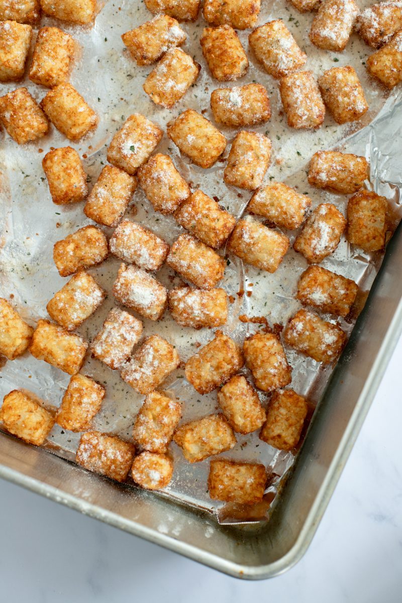 Frozen tater tots on a baking sheet.