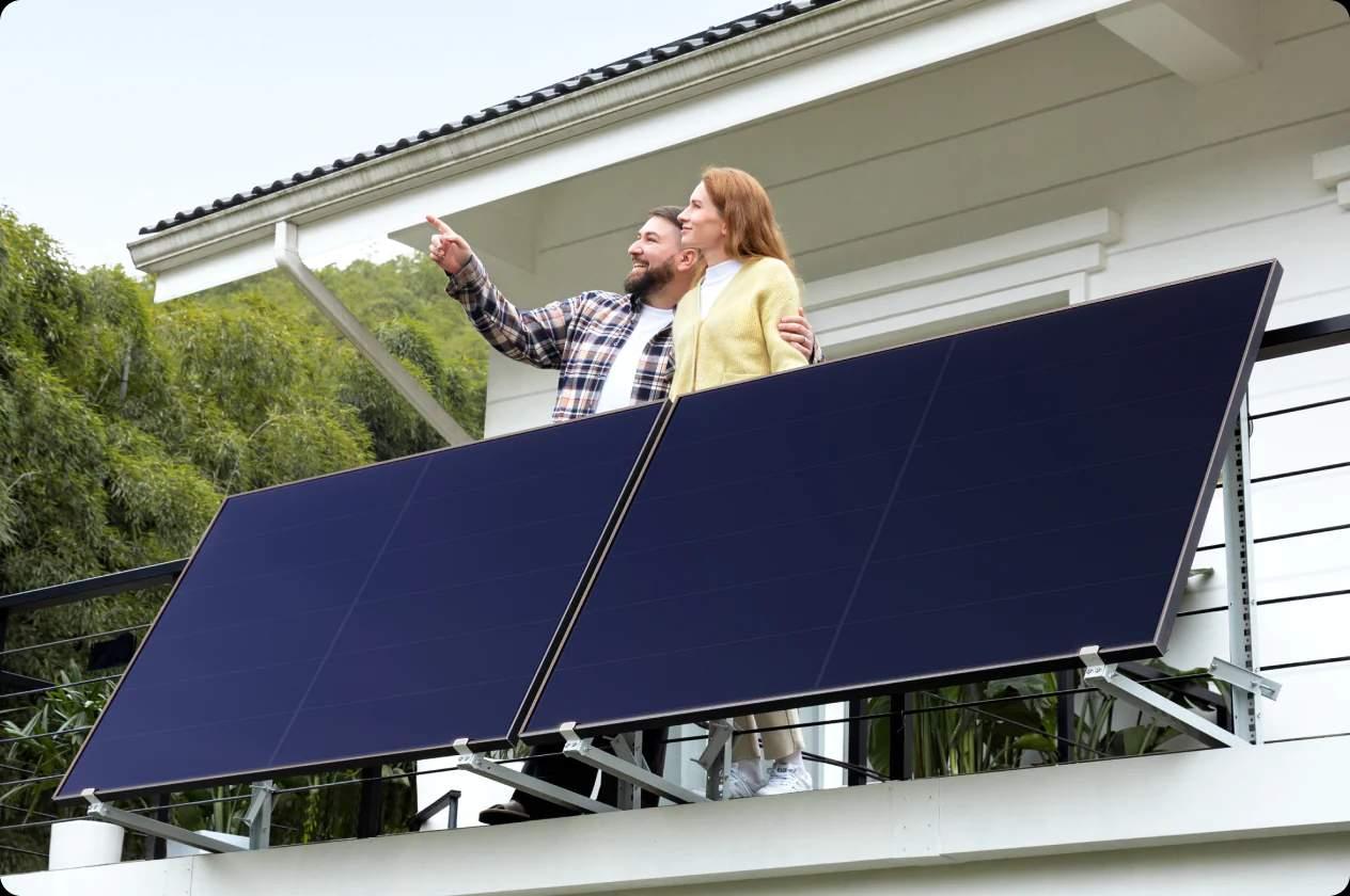 A person and person standing on a balcony with solar panels

Description automatically generated