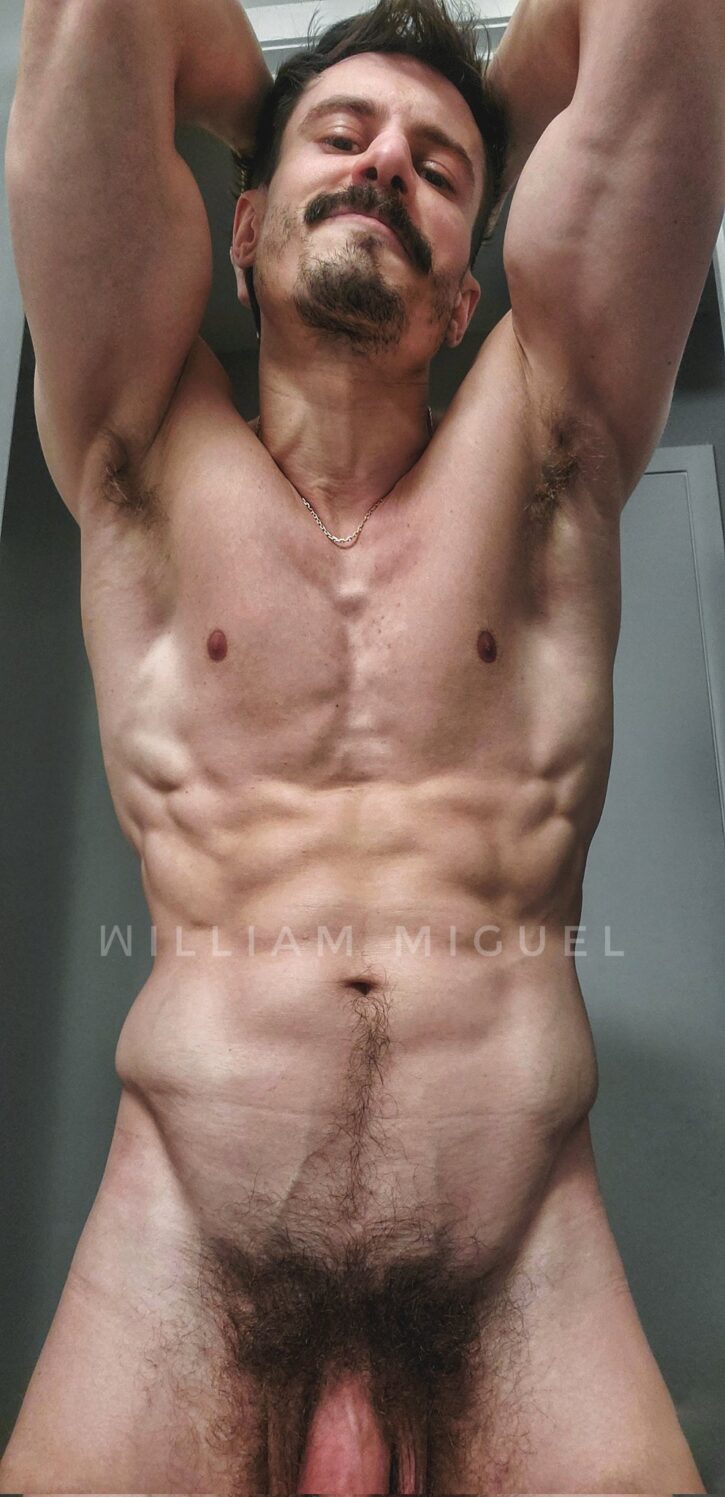william miguel flexing his biceps with his  arms behind his back showing off his flaccid dick