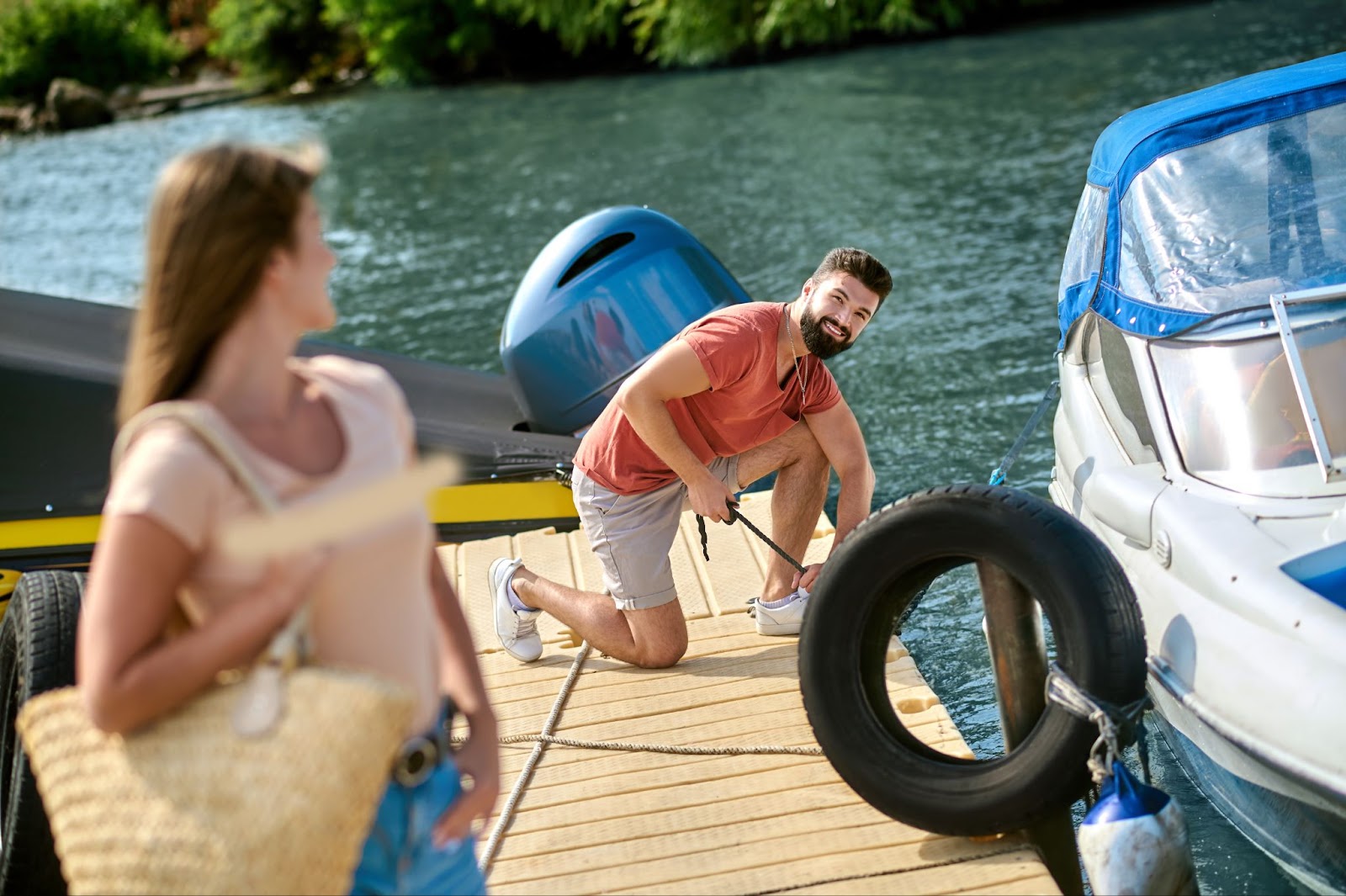 A man and a woman stare at each other near the boat on a dock. 