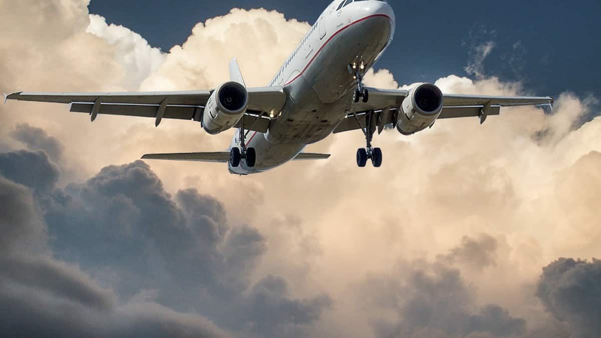 White and Red Plane Beside Clouds Low-angle Photography