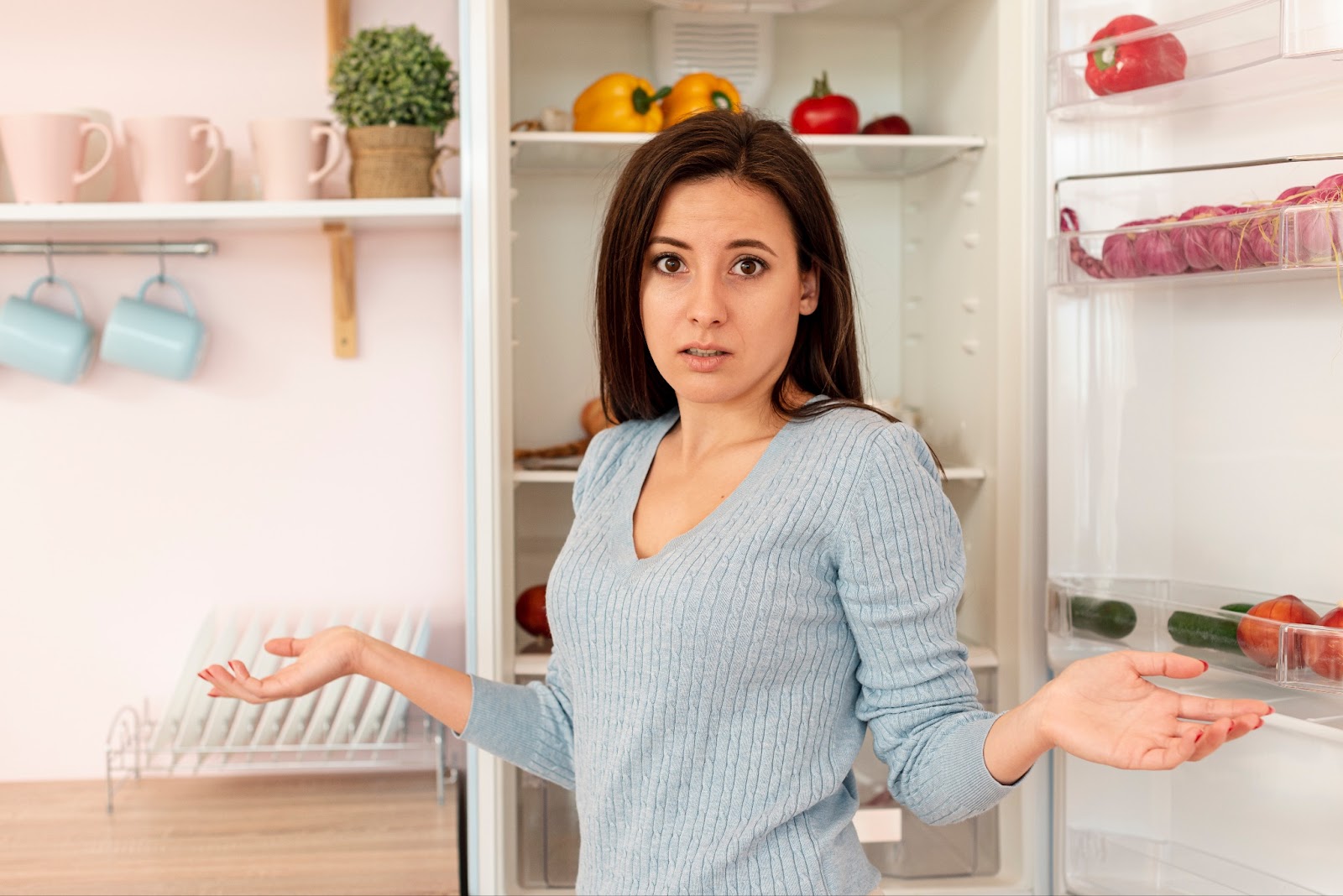 Confused woman in the kitchen, thinking why her New Samsung Refrigerator isn't making ice