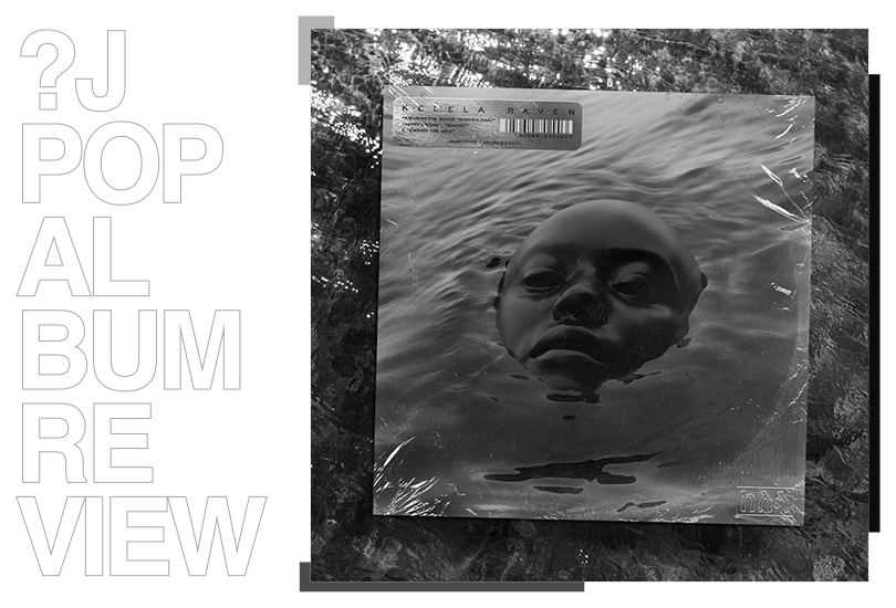 A vinyl of Kelela’s album ‘Raven’. Laying on a surface of water.

The cover features a desaturated render of Kelela with jet black skin, with her face partially submerged in water.