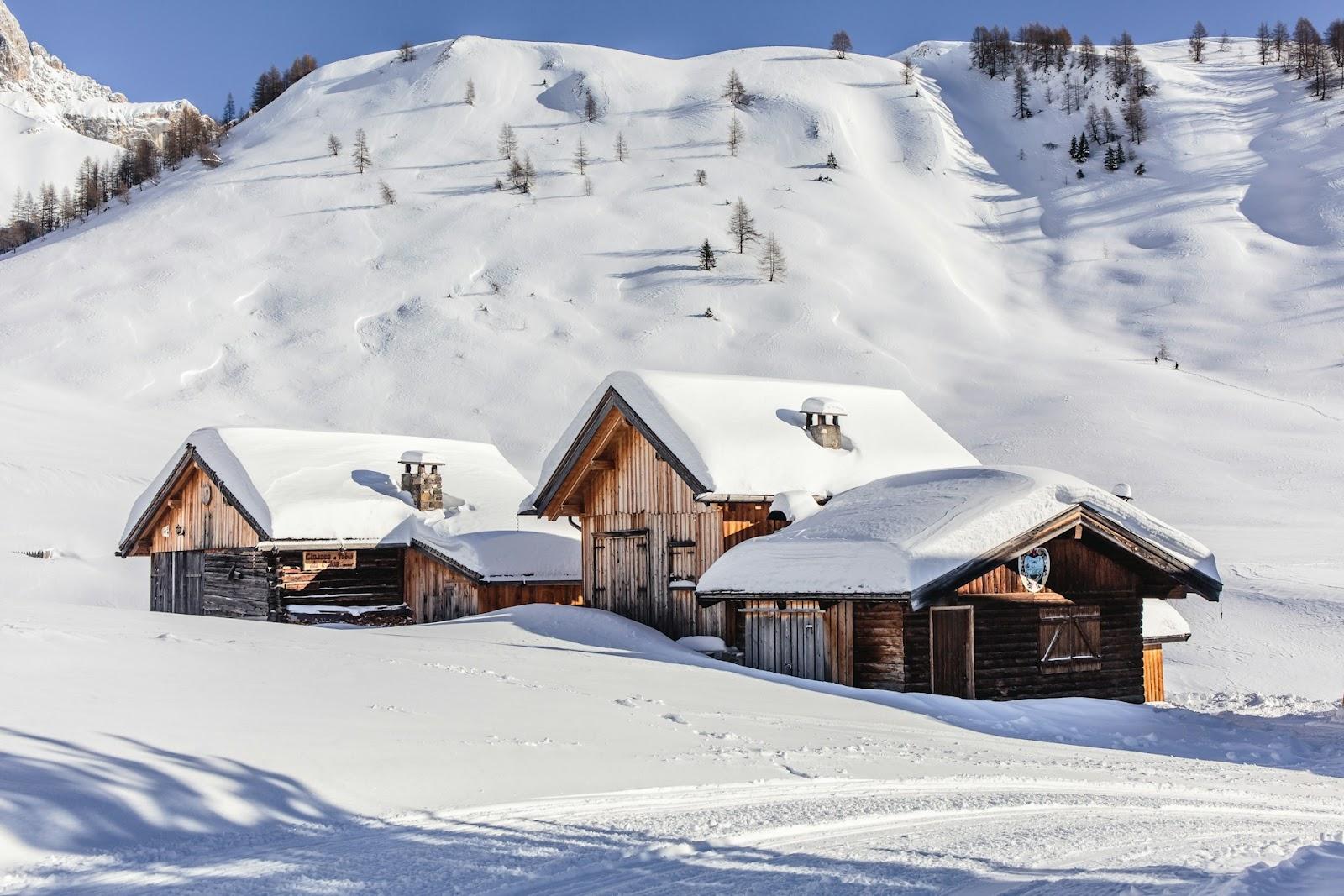 three wooden chalets in the snow