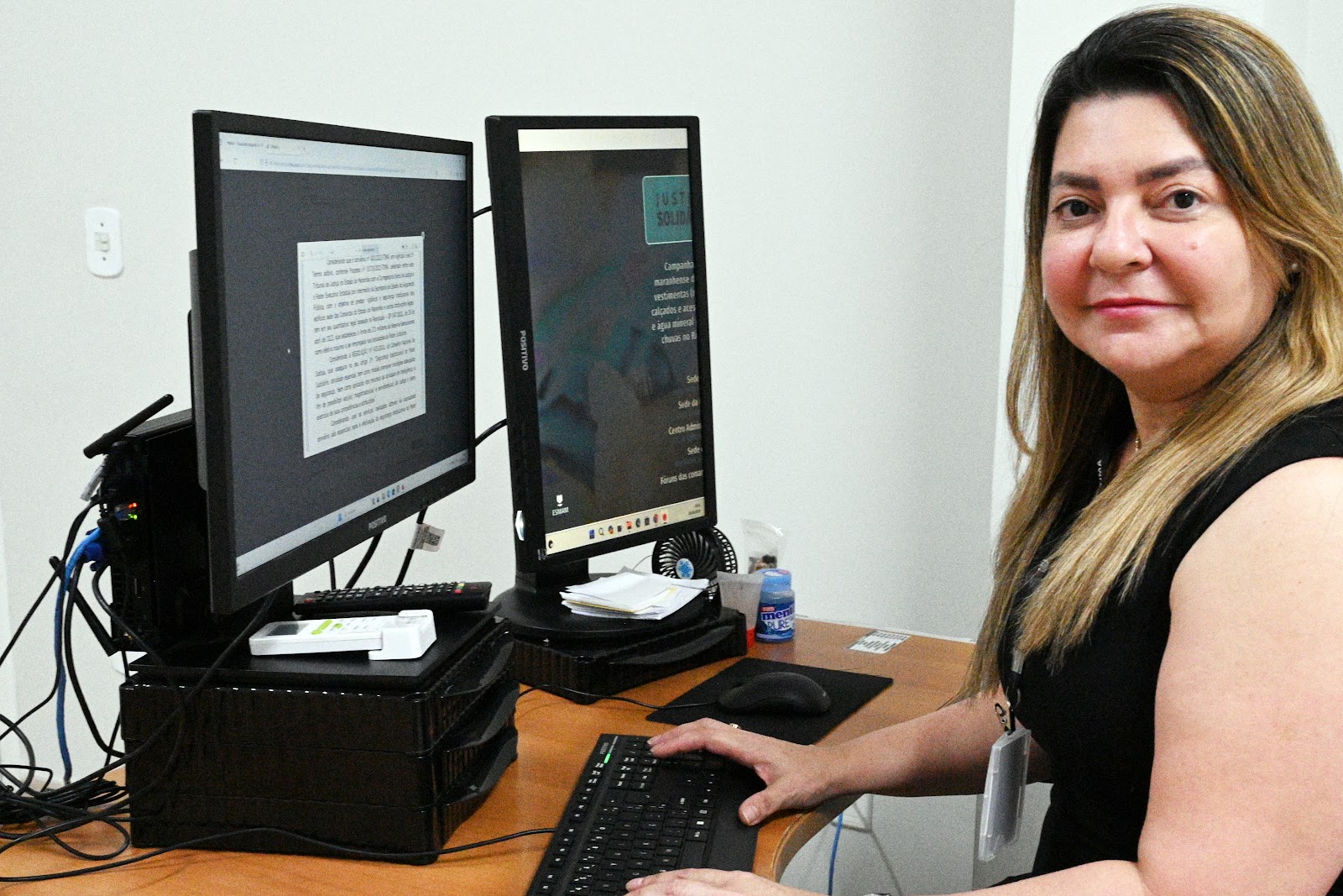 A imagem mostra uma pessoa sentada em frente a um monitor de computador com texto nele. O rosto da pessoa está borrado para preservar a privacidade. O monitor exibe uma lista de tópicos, mas o texto não está claro o suficiente para ser lido completamente ou transcrever possíveis problemas de tarefa. O cenário parece ser um ambiente de escritório, o que pode ser relevante para discussões sobre configurações de trabalho ou uso de computadores lá. No entanto, sem mais contexto ou texto mais claro, não é possível inferir informações específicas adicionais a partir desta imagem.