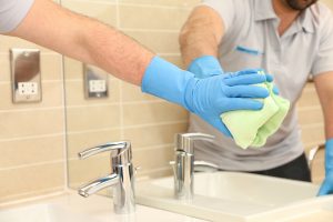 cleaning bathroom taps and mirror