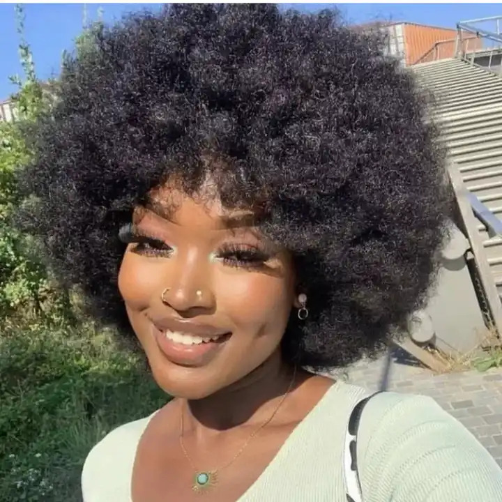 Woman wearing Afro hair wig smiling at the camera