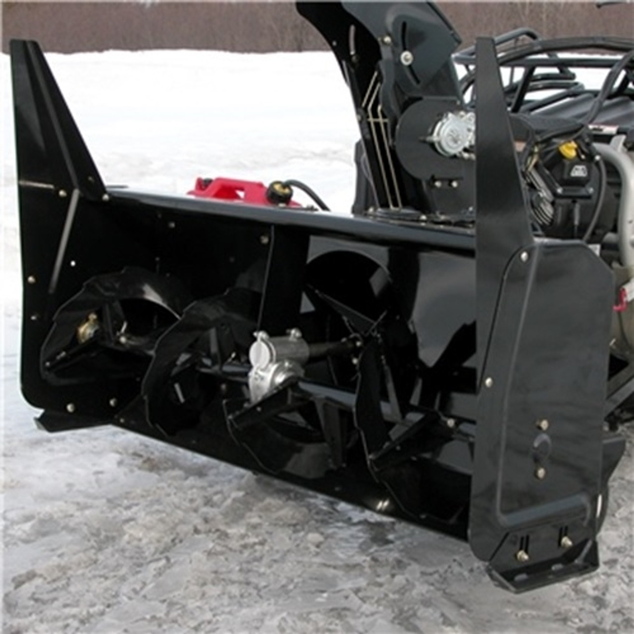 A front-oblique picture of a Polaris General Snowblower by Bercomac, installed on an ATV and parked on icy terrain.