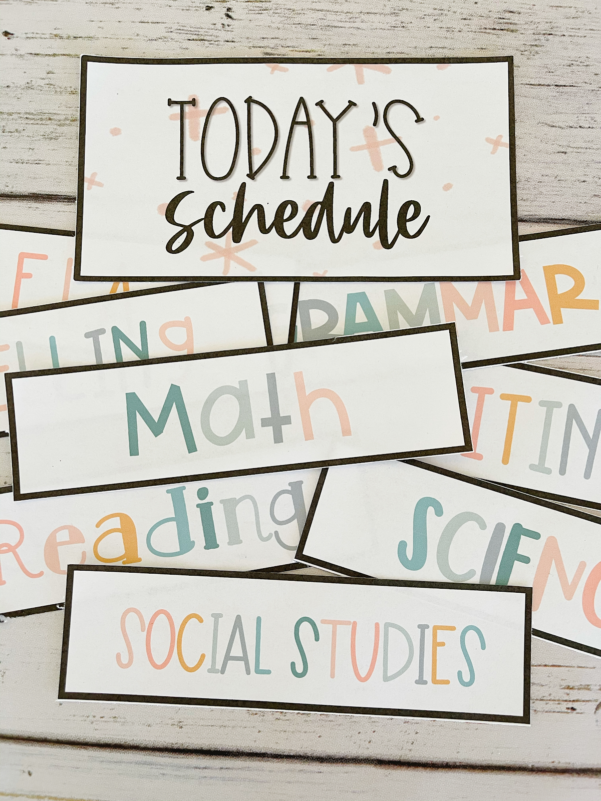 This image shows a pile of schedule cards with different subjects listed. Some of the cards read "Math", "Reading", "science", and "Social Studies". 