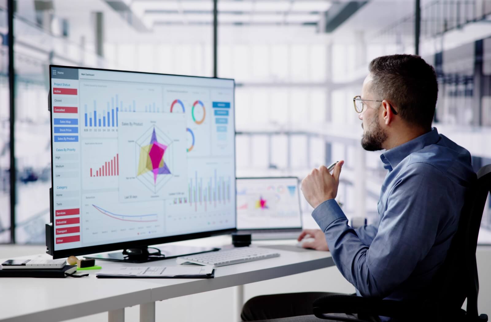 A professional-looking man reviewing a series of charts on his computer.