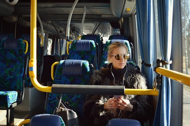 Mulher usando fone de ouvido no ônibus