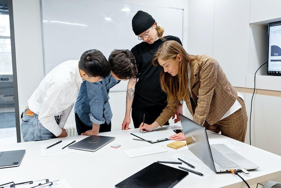 Free People Standing Around the Table Having a Discussion Stock Photo