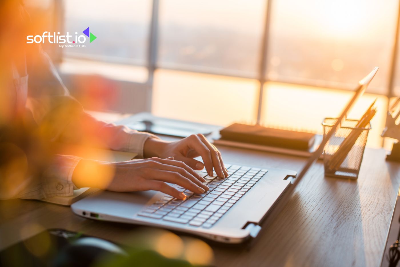 Person typing on a laptop during golden hour