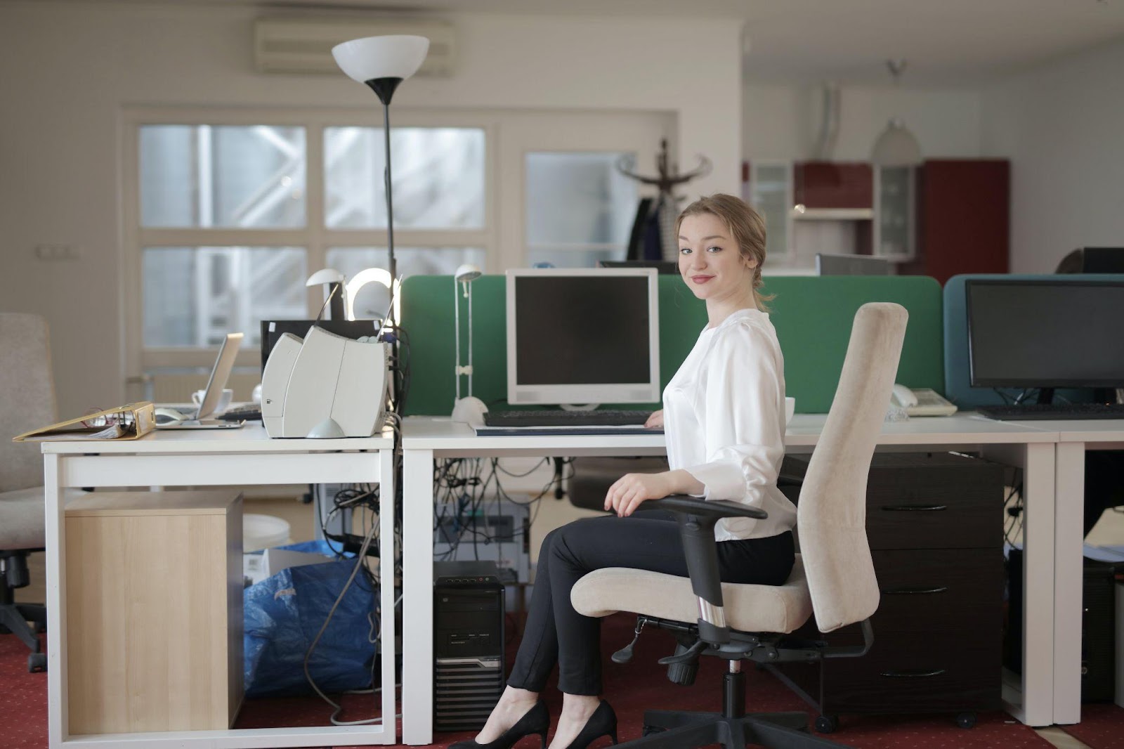 a woman with great sitting posture at work, but unable to get back support due to the depth of the seat and the front edge of the seat being too high.