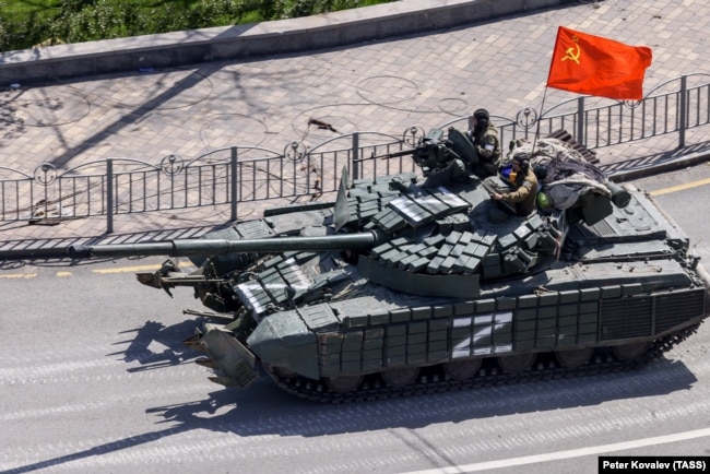Російський танк із прапором СРСР на вулицях окупованого Маріуполя. Україна, 2022 рік