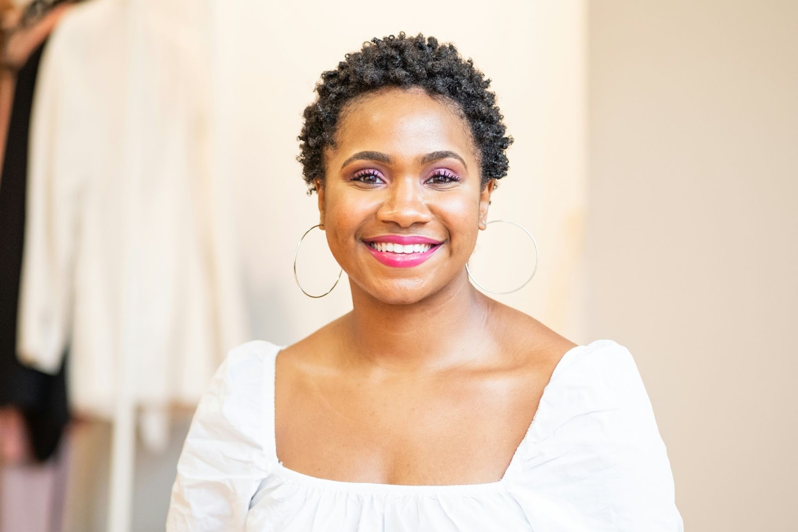 A woman with subtle makeup is smiling gently to pose for her professional headshots. 