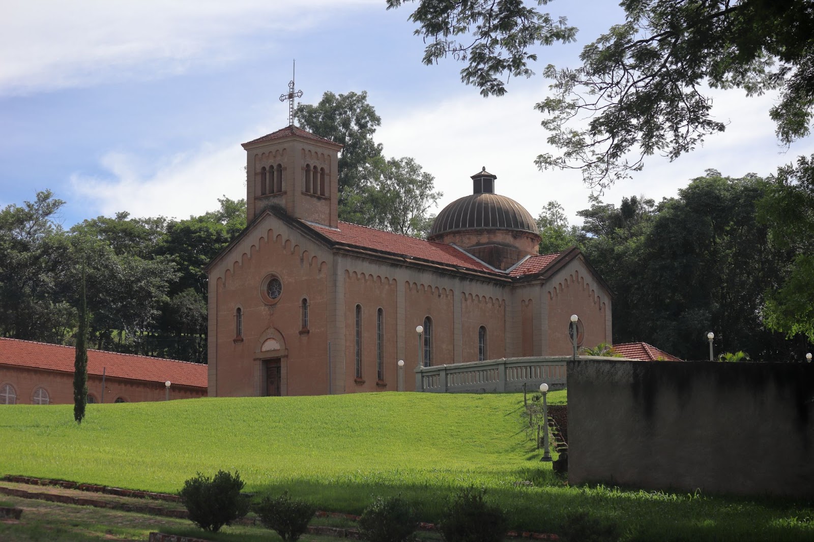 Capela Monte Alegre, templo de arquitetura inspirada nas antigas igrejas toscanas. A fachada de tijolos aparentes tem janelas estreitas, uma torre e uma cúpula arredondada