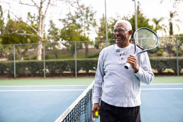 Portrait of a senior black man on the tennis court A senior black man smiling man happy stock pictures, royalty-free photos & images