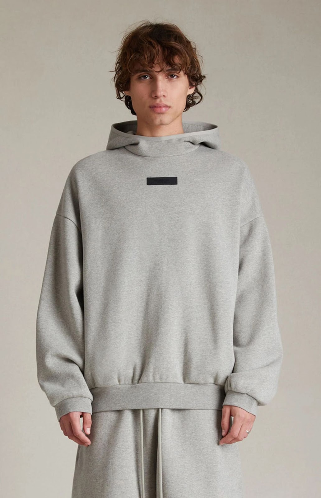 male model wearing a gray essentials hoodie