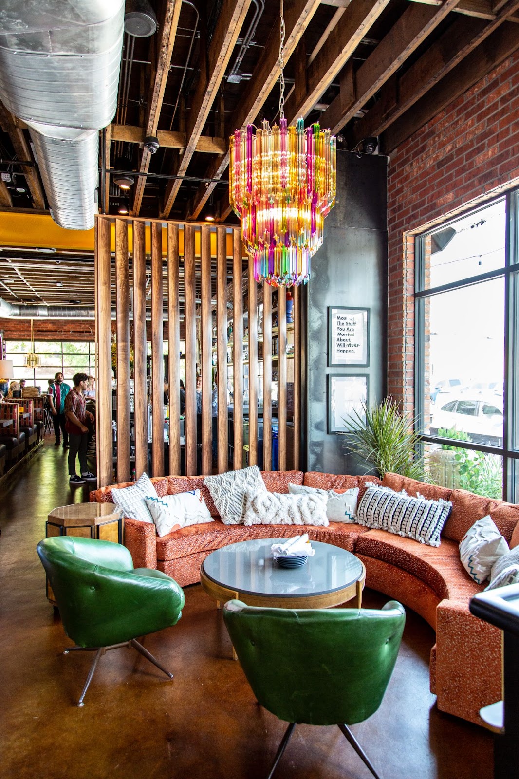 Postino greeting area with seating and a colorful chandelier 