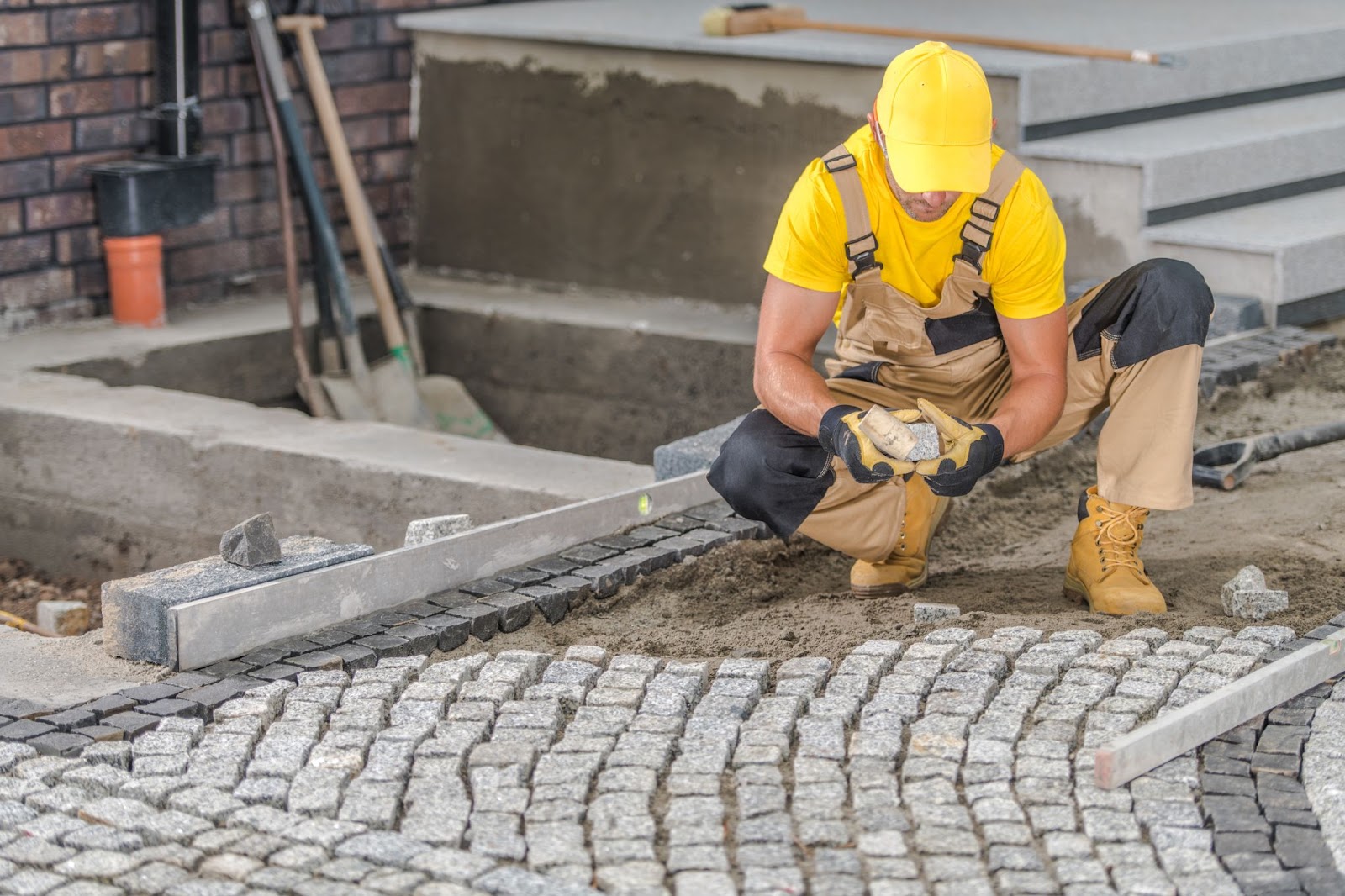 A man installing stamped concrete in the front yard. 