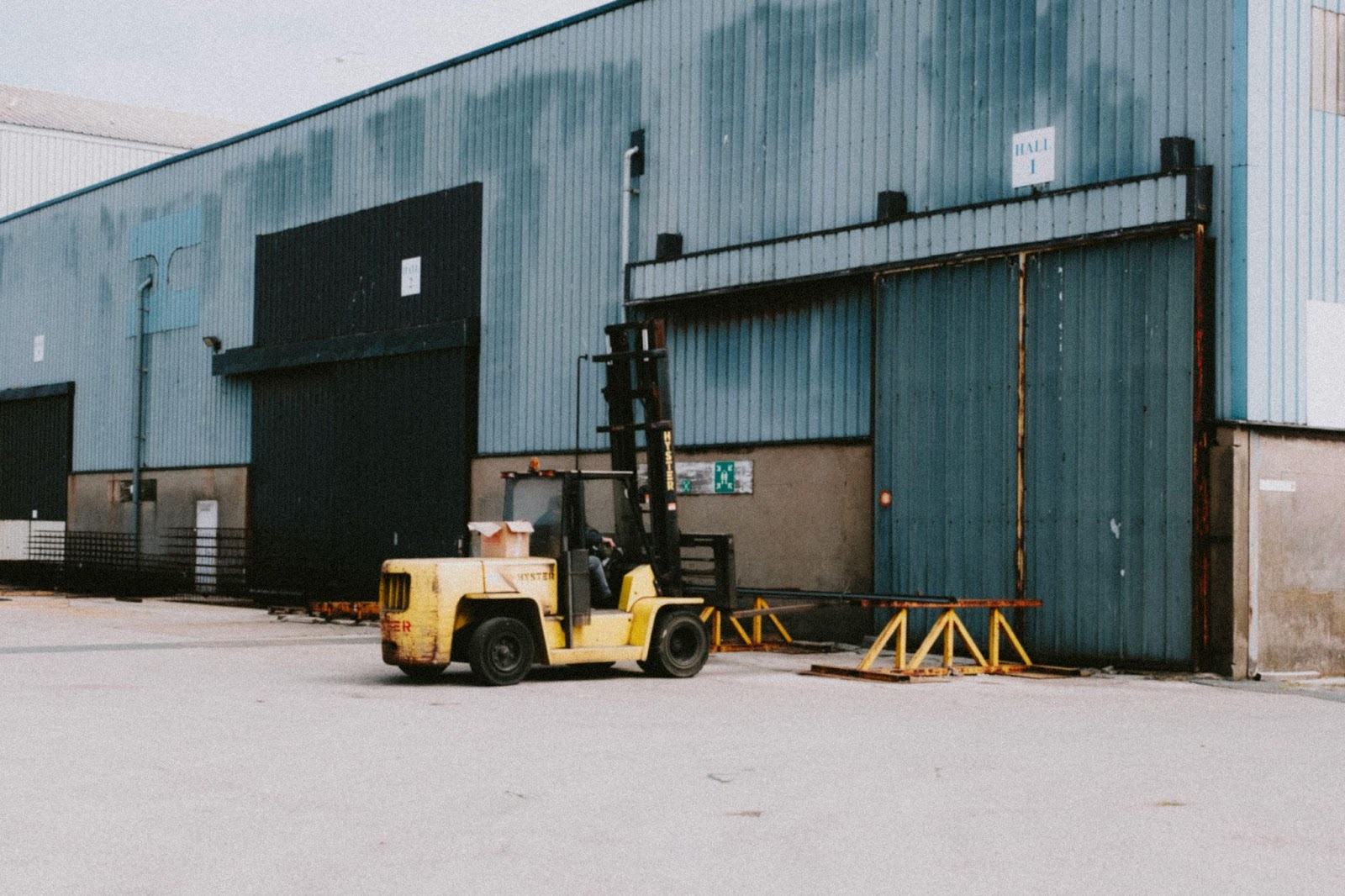 A yellow forklift outside a warehouse shipping yard