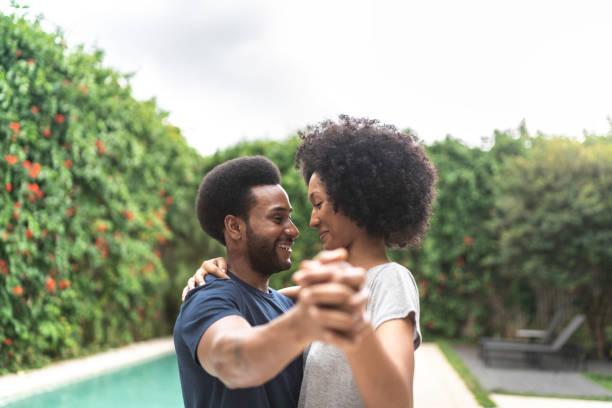 lovely african couple dancing at home - young black couple in love stock pictures, royalty-free photos & images