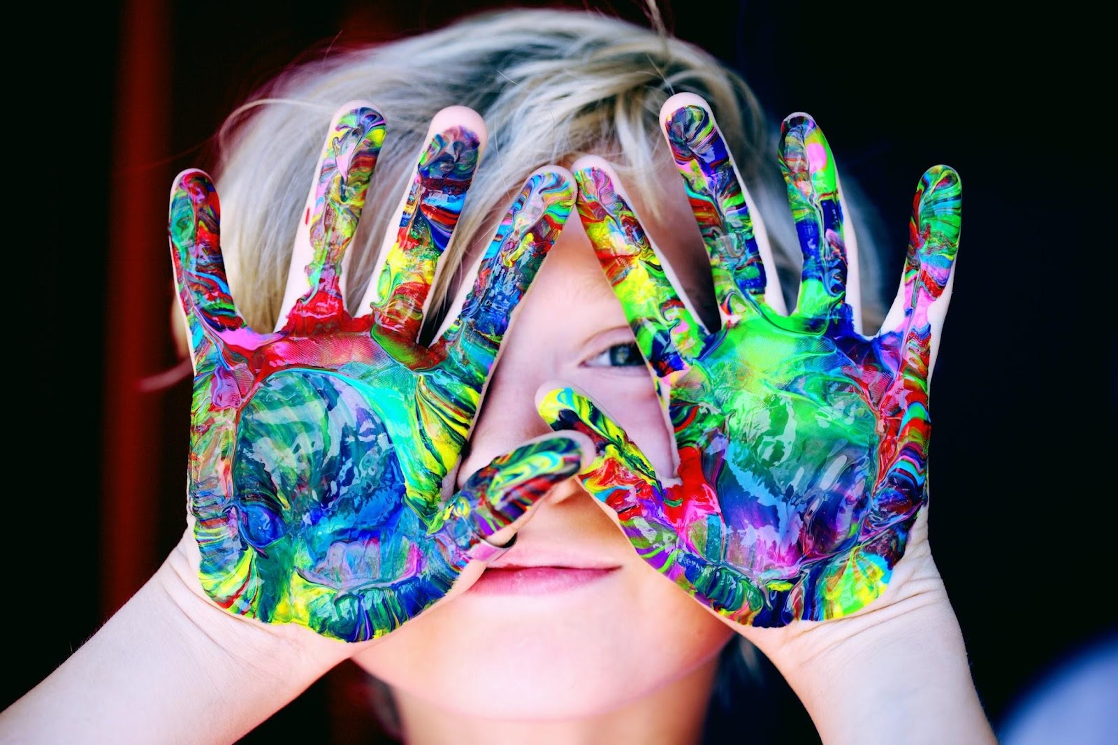 boy with paint all over palms of his hands