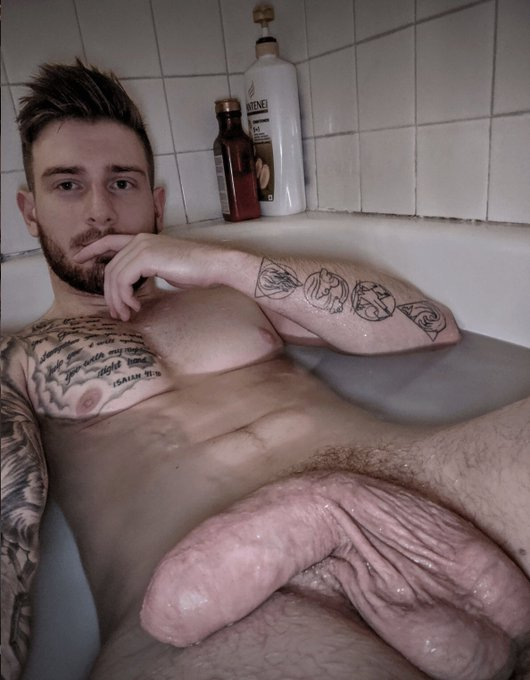 gay tattoo naked male posing in bathtub for selfie showing off his fat thick flaccid dick in the bathwater