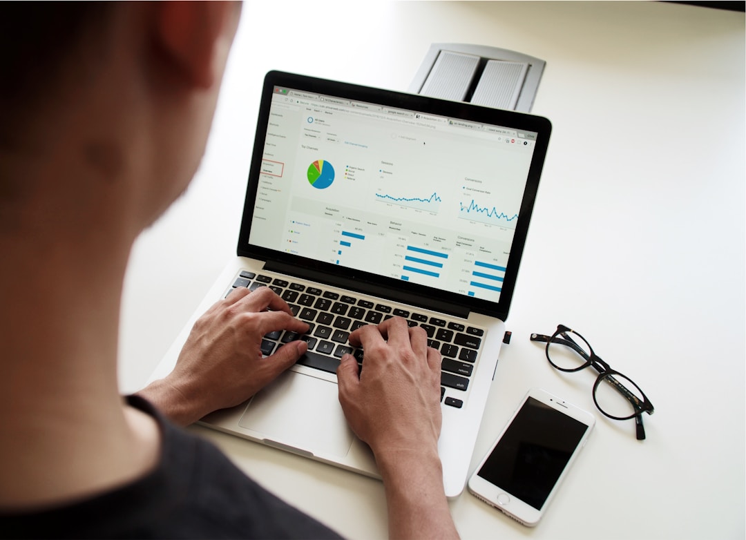 A man typing on his laptop, showing data analysis.