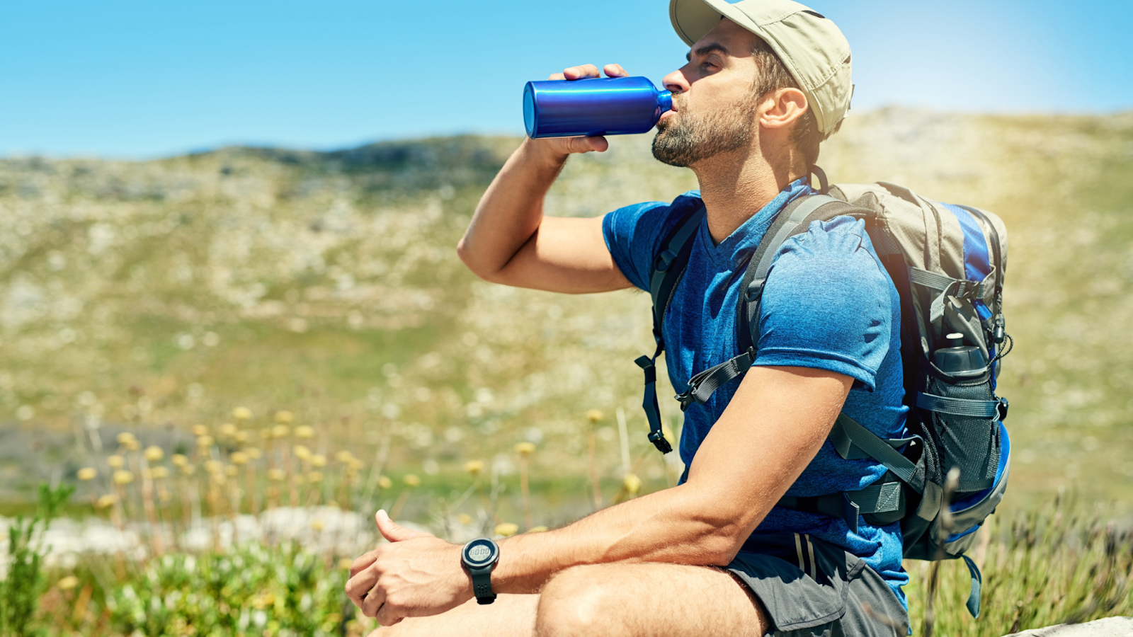 man drinking water on hike learning how to stay fit while traveling