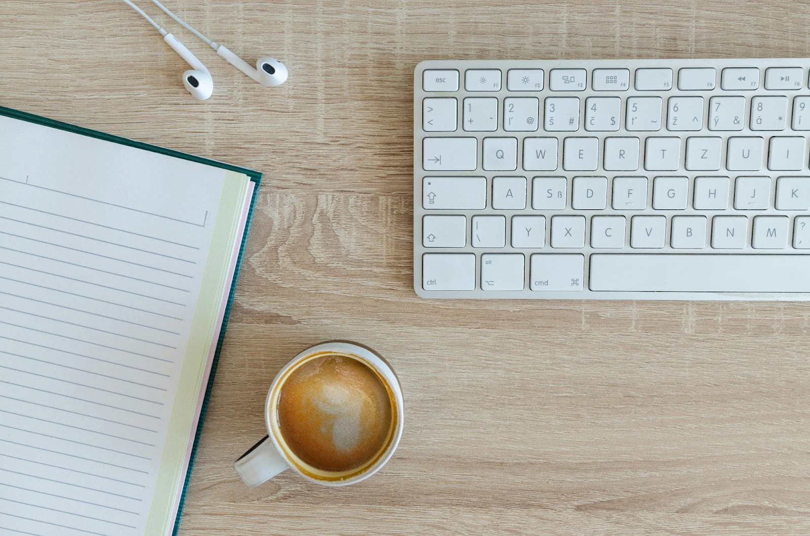 a cup of coffee next to a keyboard and a computer