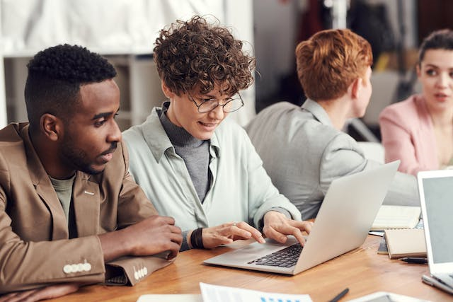 A group of people looking at a computer

Description automatically generated