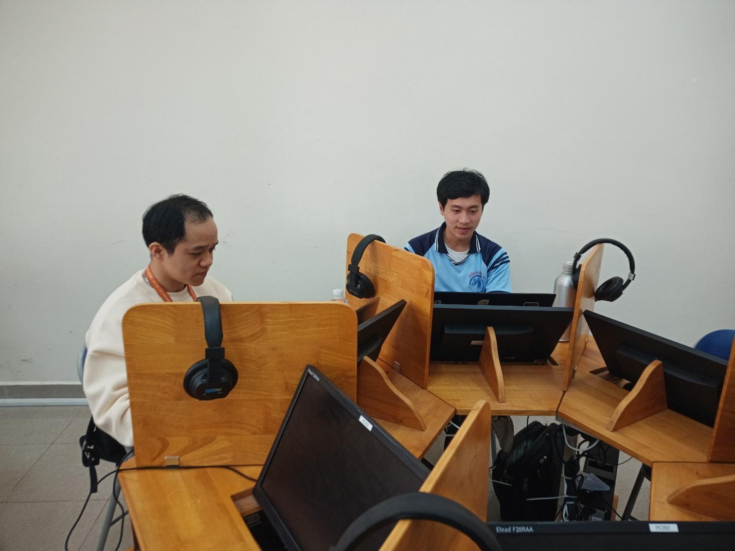 A group of men sitting at a desk with computers

Description automatically generated